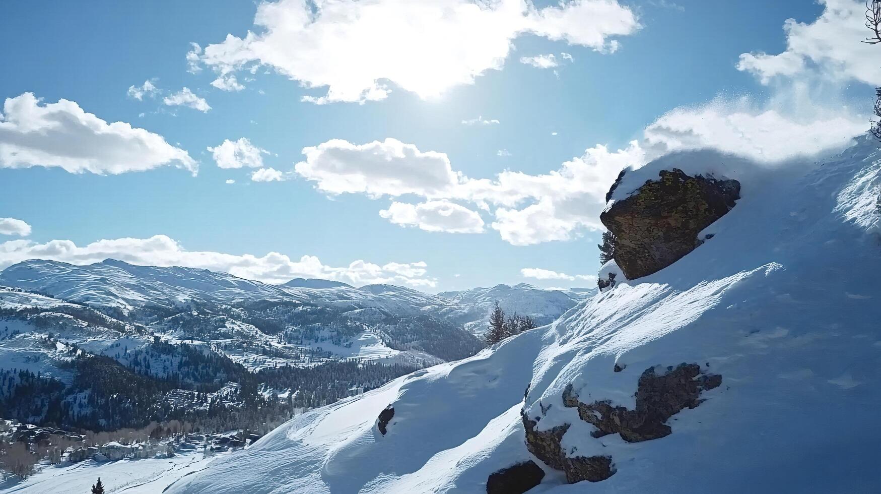 Snow blowing off rock on sunny mountain top photo