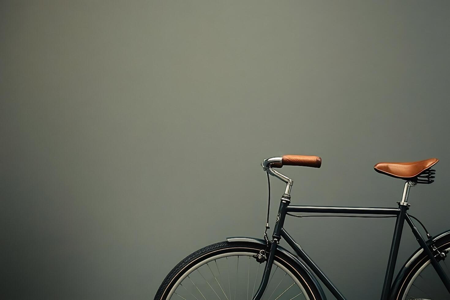 Vintage bicycle with leather saddle and handlebars on green background photo