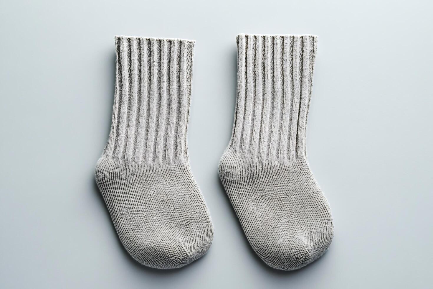 Pair of gray knitted socks lying on gray background photo