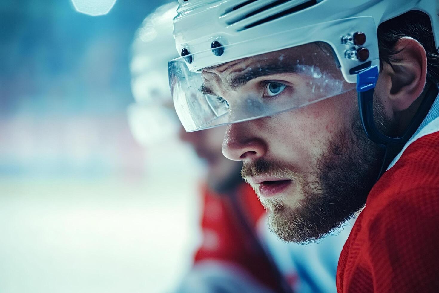 Focused hockey player watching game from bench photo