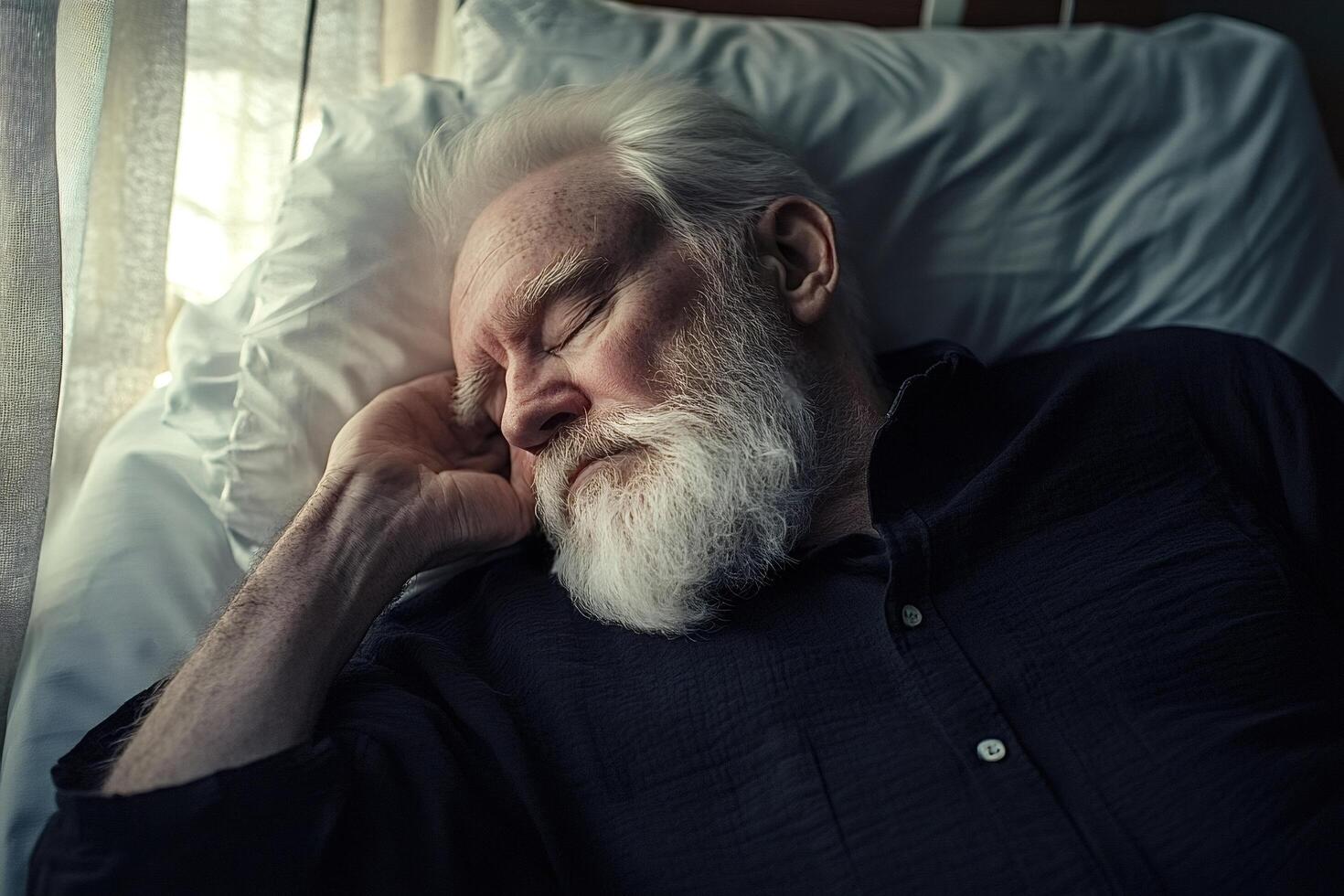 Senior man sleeping peacefully in bed by window light photo
