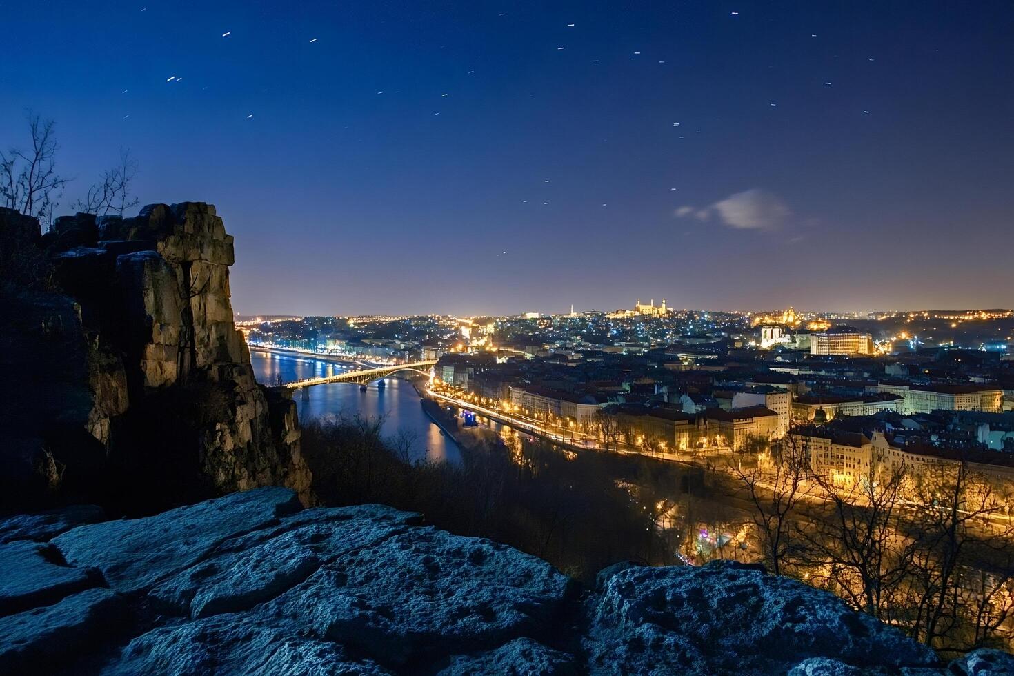 Starry night sky over illuminated prague with vltava river and bridges, vysehrad photo