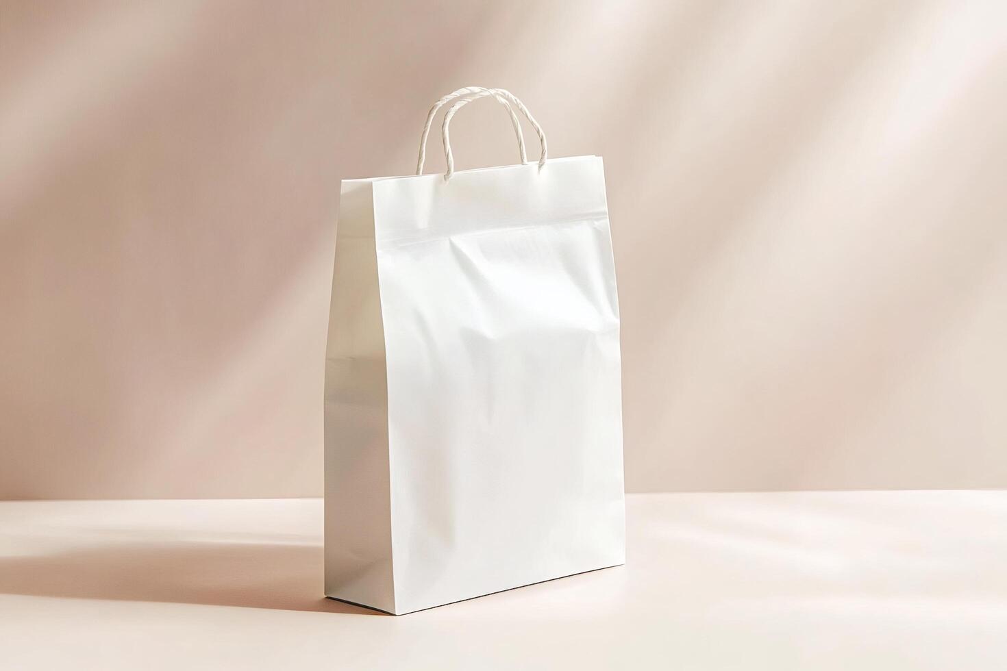 White shopping bag standing on pink surface with dramatic lighting photo