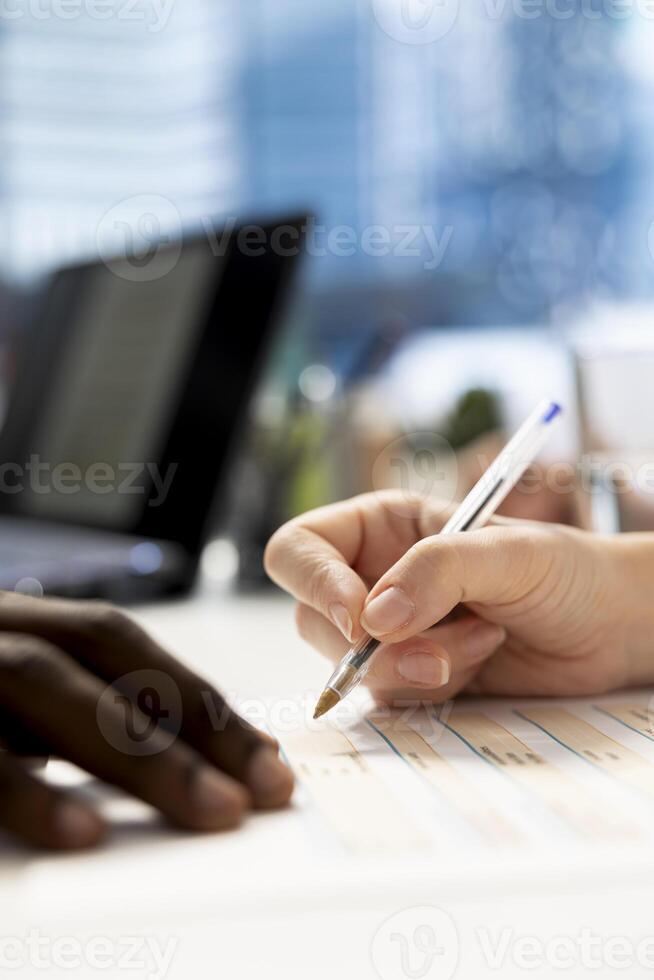 HR professional signing documents after ensuring job candidate possesses necessary qualifications fitting for company culture. Close up of recruiter signing salary package and other benefits files photo