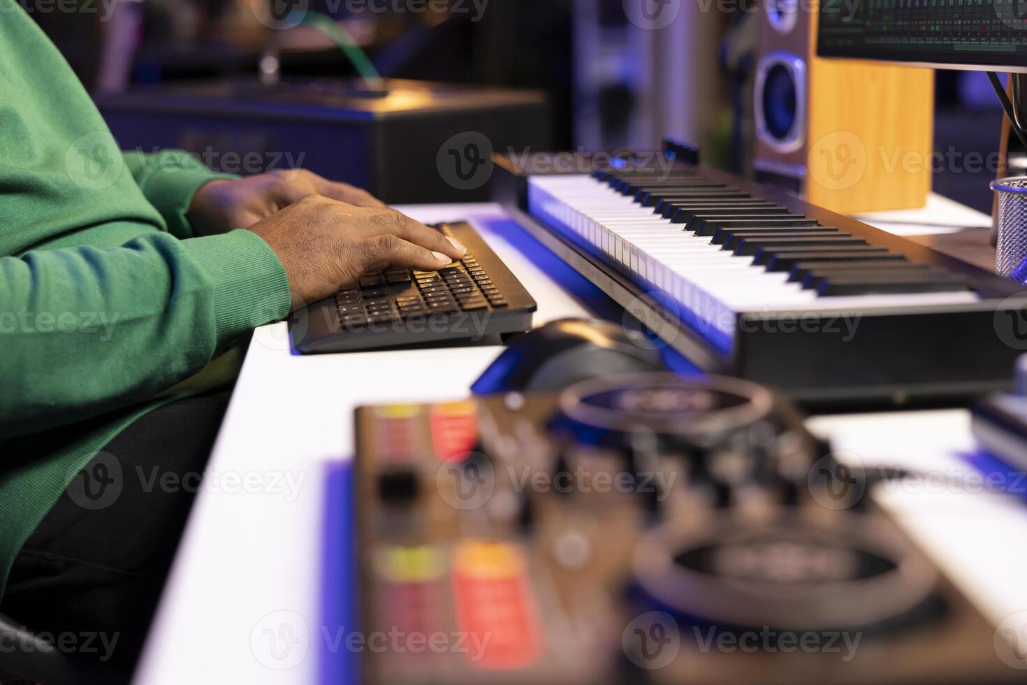Sound engineer working with mixing console and daw software to edit audio recordings, adjusting volume levels with pre amp knobs in his home studio. Producer uses stereo gear. Close up. photo
