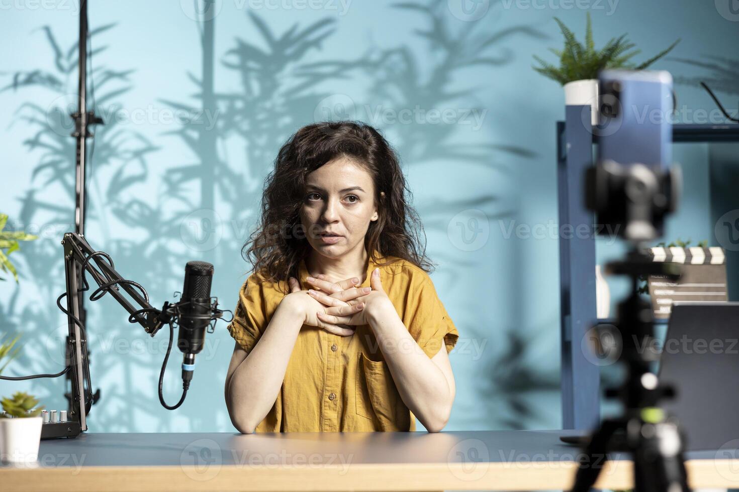 Influencer filming addressing concerning allegations about her to worried subscribers, making excuses, filming with smartphone. Online star explaining behavior in front of fans photo