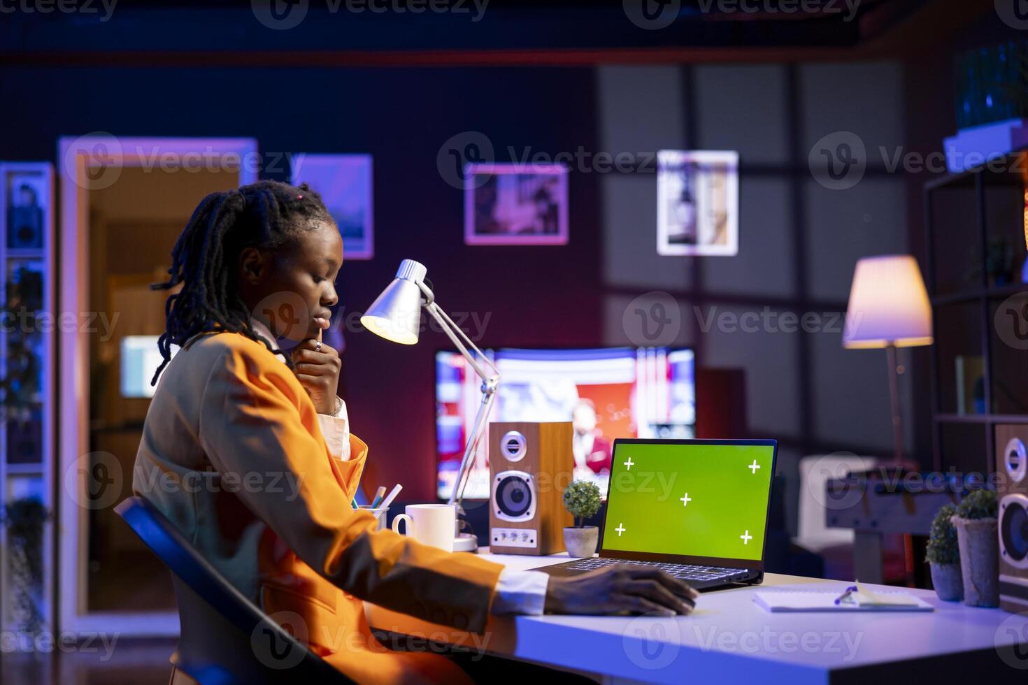 Teleworking woman in living room office using chroma key laptop to plan business development. Remote worker doing project research, typing on green screen device keyboard photo