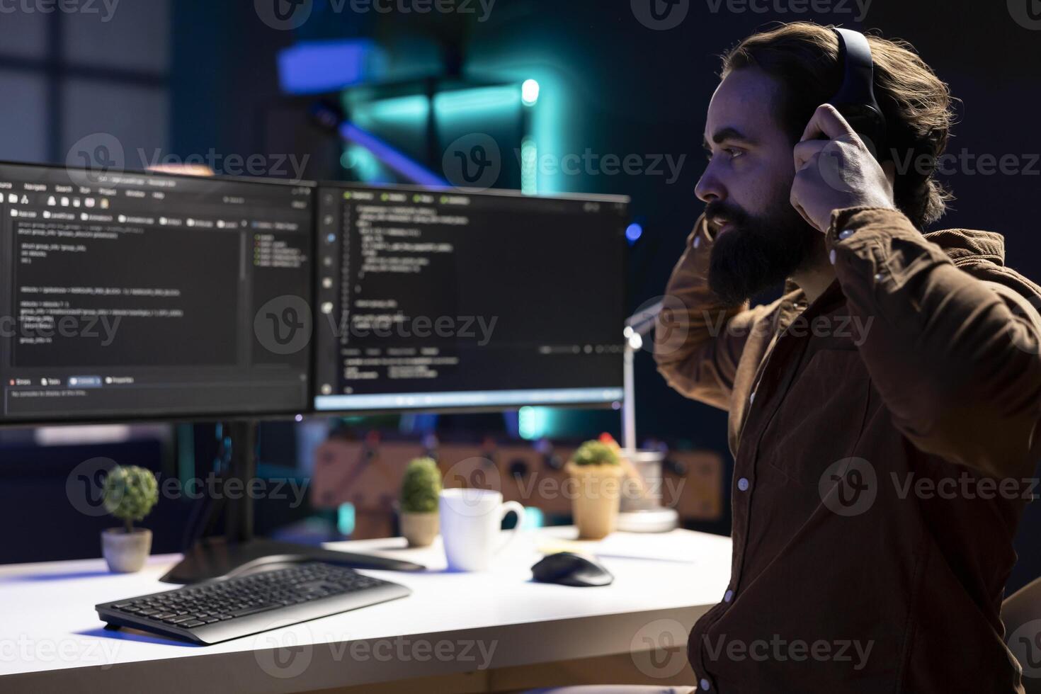 Programmer enjoying podcasts and futureproofing company network from downtimes and unexpected system failures. IT expert putting headphones on to listen audiobooks while increasing data security photo