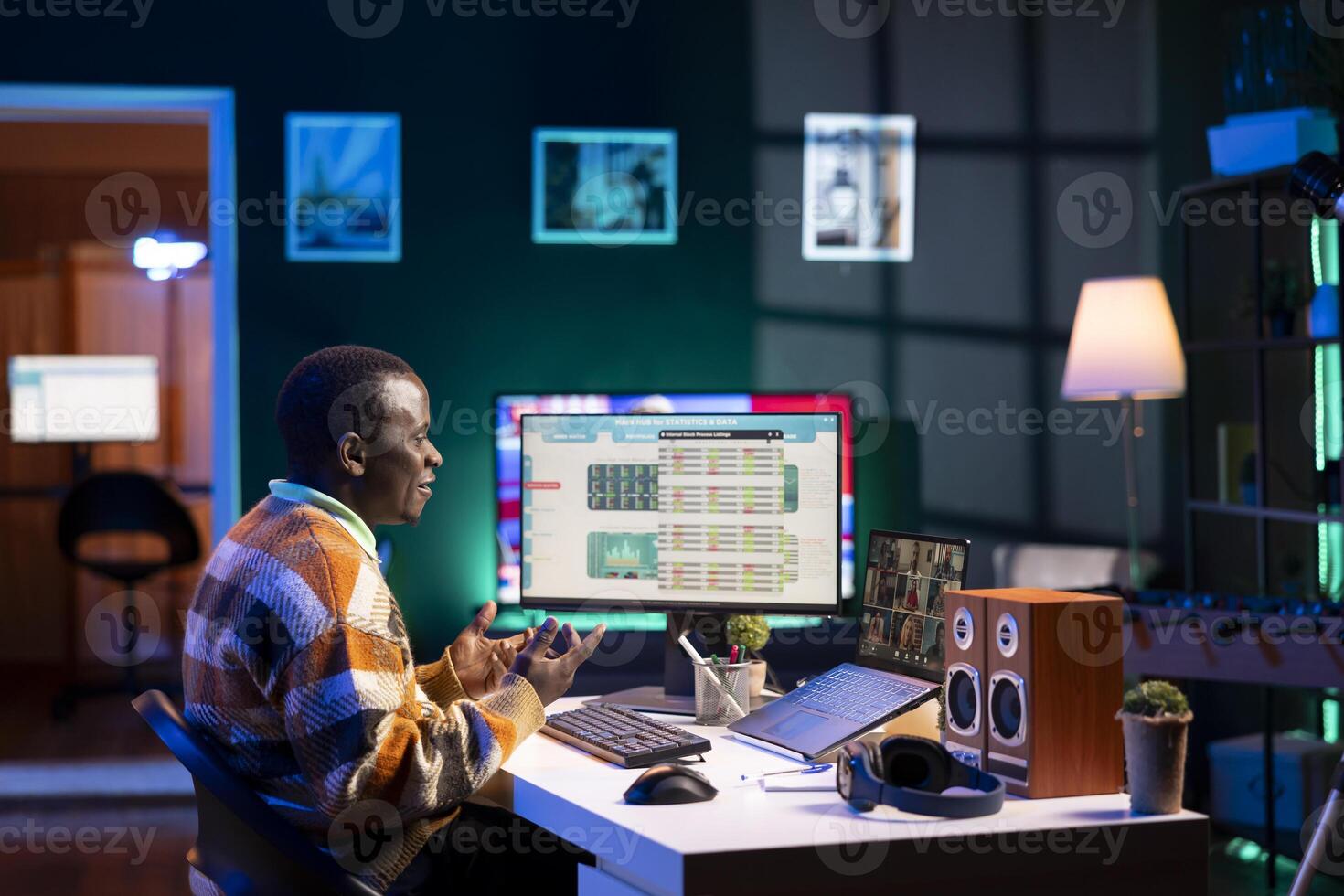 Black man waving on call and discussing about business infographics, reviewing monthly budget balance and working remotely. Staff focused on conversation during online meeting on pc. photo