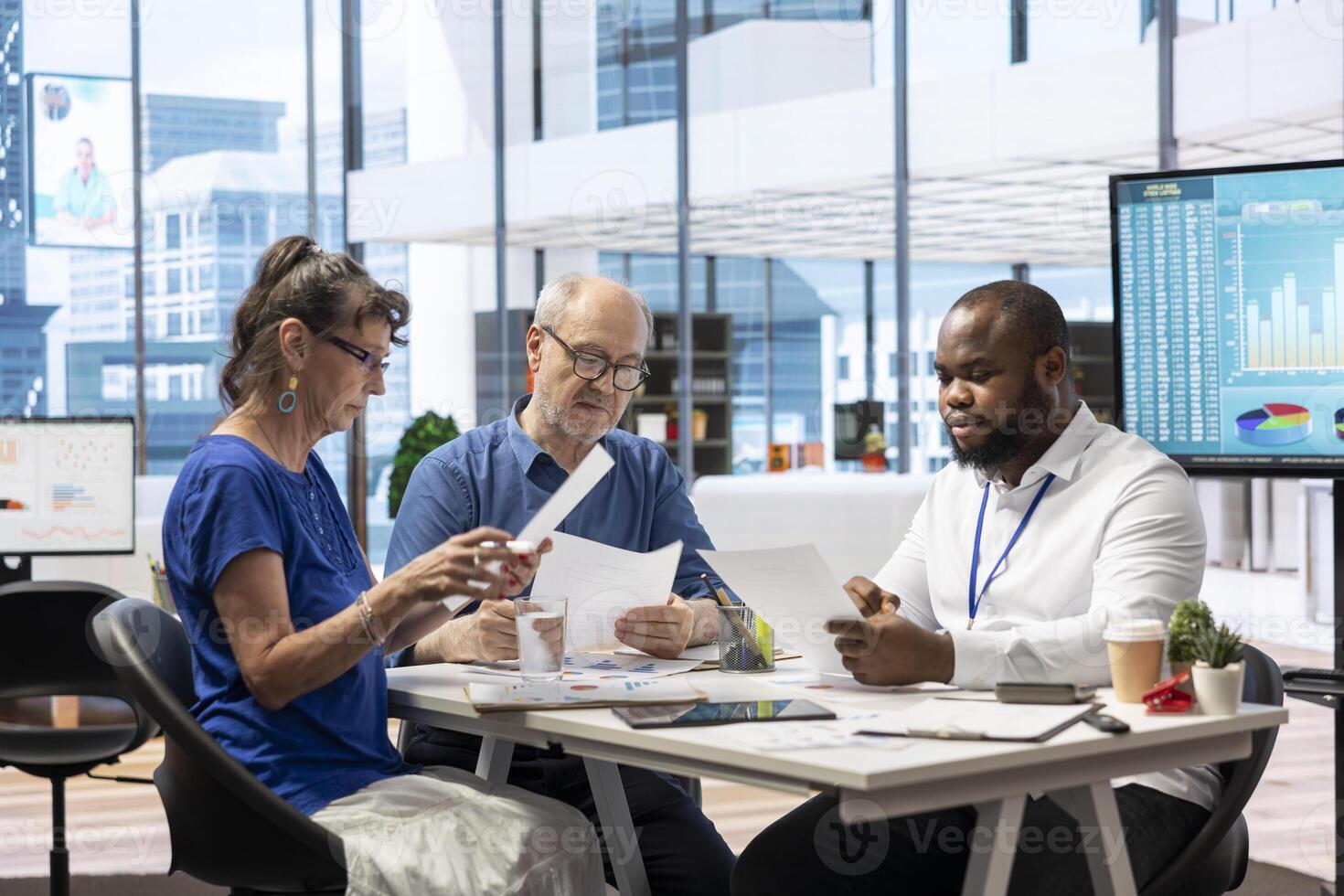 Old people asking for professional advice from financial expert, counseling on retirement plans and investments. Helping middle aged pair to invest money and increase their income. Maximize savings. photo