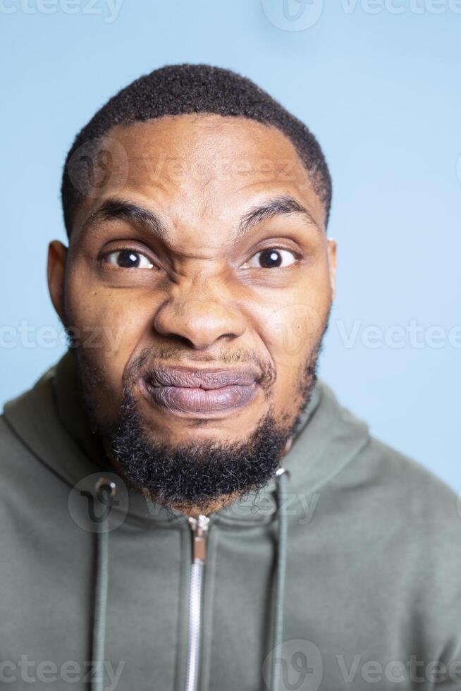 Angry irritated person screaming in front of the camera and showing his frustration, getting aggressive and furious about something. Young adult with mental health problem shows conflict. photo
