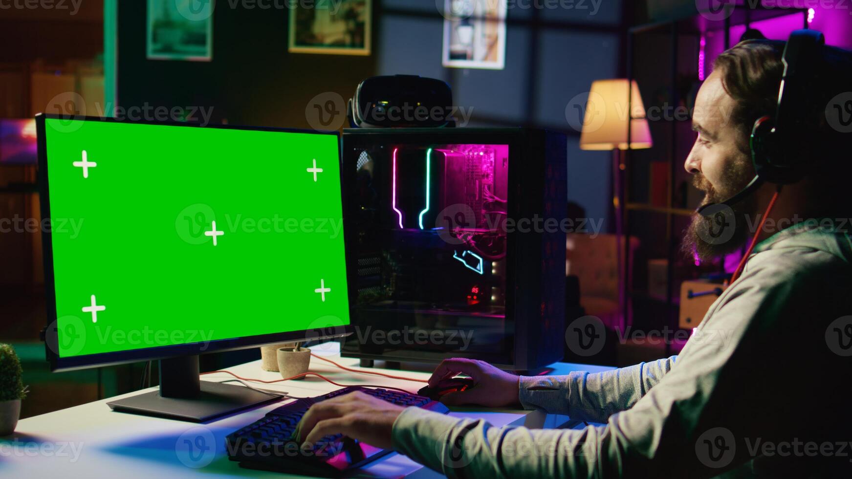 Man having fun by using green screen computer monitor to play singleplayer videogame. Professional gamer using mockup PC desktop to complete levels in game, talking with friends photo