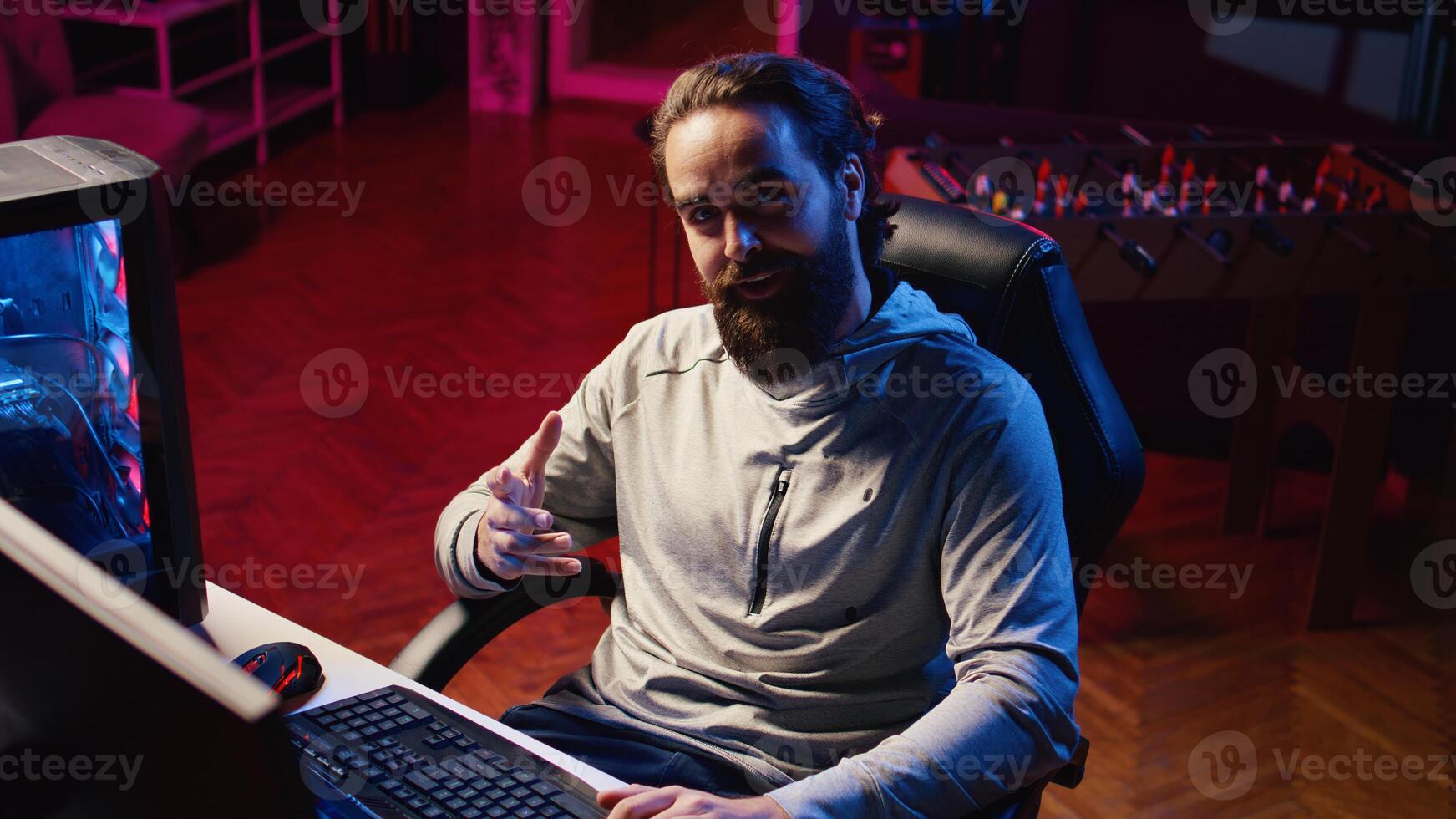 Content creator in studio streaming for online viewers, talking with them about upcoming esports competition. Pro gamer discussing with internet audience watching him during live broadcast photo