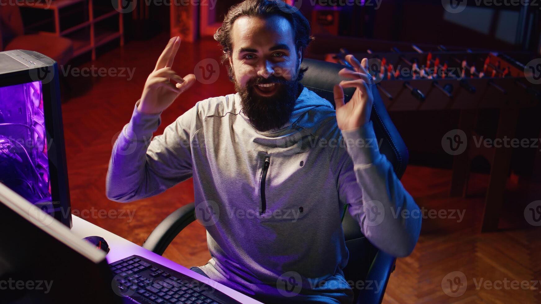 Gamer streaming, greeting audience, preparing to showcase game winning strategy to gaming community during livestream. Content creator chatting with viewers, presenting ways of winning videogame photo