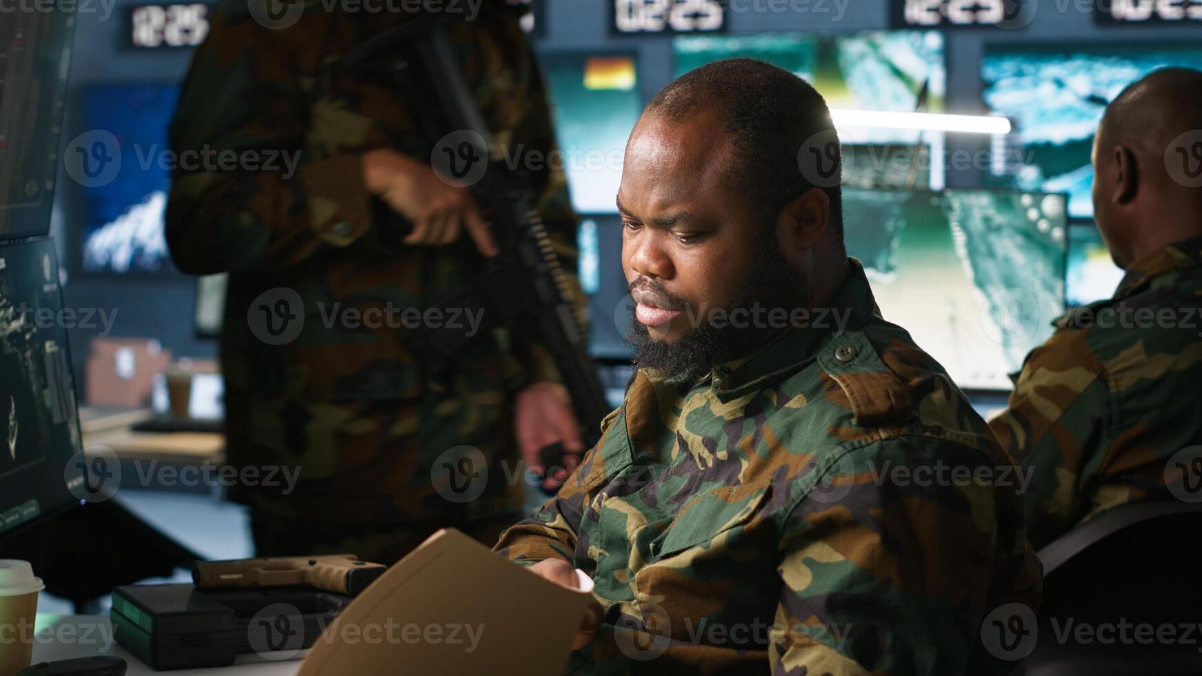 Counterintelligence specialist in military HQ base gathering information on enemy troops. African american agent in base of operations doing assessment of enemy vulnerabilities, tracking, camera A photo