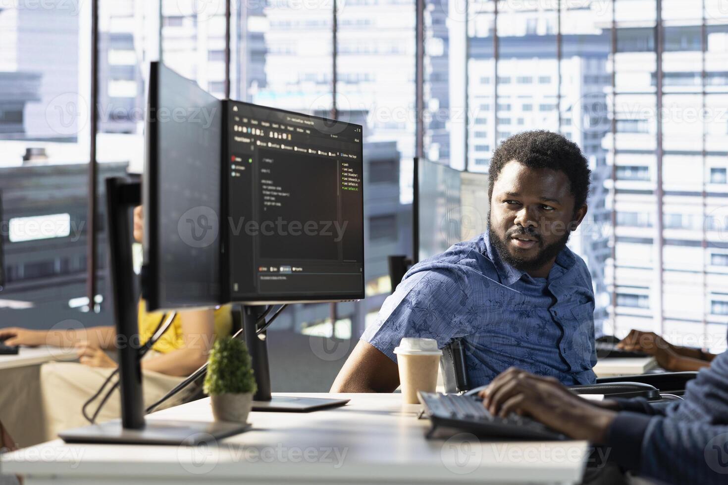 Manager in wheelchair supervising admin doing software quality assurance, reading source code on computer and implementing it. Team leader with disability checking on IT worker inspecting coding on PC photo