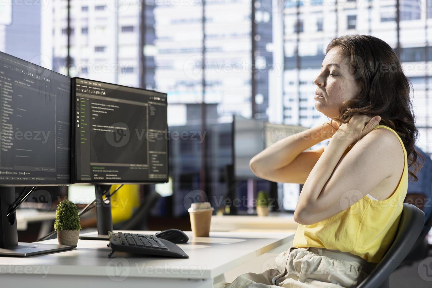 Developer suffering neck pain while fixing applications issues, dealing with databases and server configuration. Fatigued woman feeling overworked while optimizing company software photo