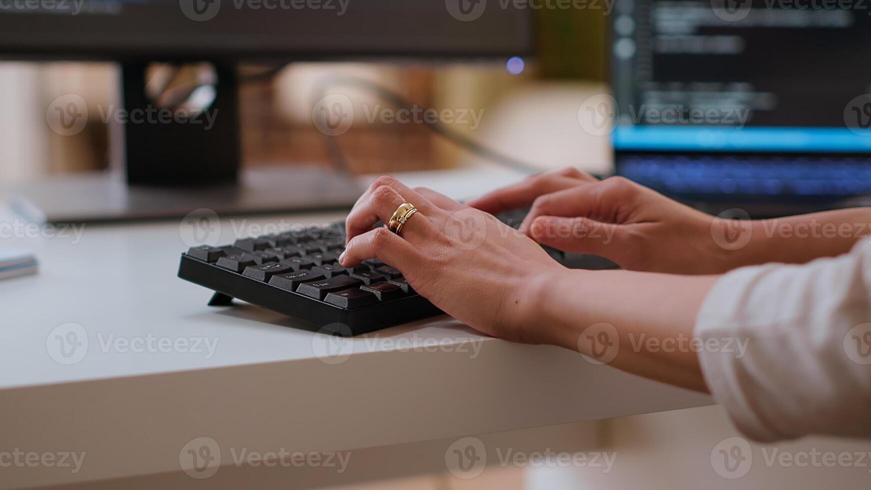 Professional software developer types code on a laptop in a sleek workspace. Asian female freelancer doing remote work on app development, software engineering and agile coding practices. Camera B. photo
