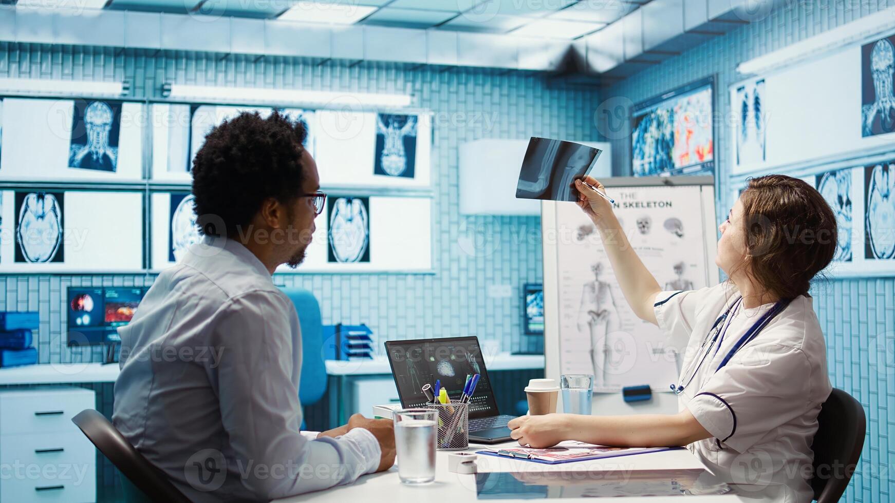 Doctor and patient interaction in a medical consultation room, featuring a tablet screen with medical results and x ray diagnosis, Highlighting technology in healthcare industry. Camera B. photo