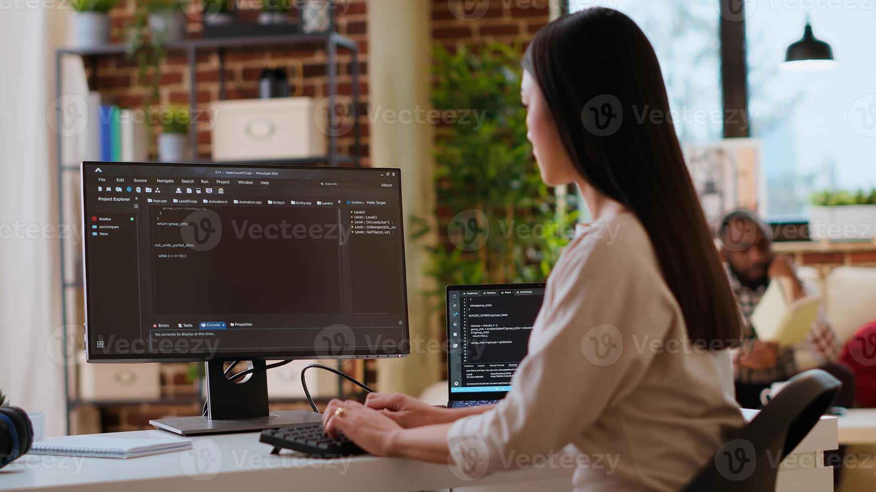Asian female developer coding cloud computing applications on pc in a modern tech workspace. Woman IT specialist focuses on the software development process for productivity and innovation. Camera B. photo