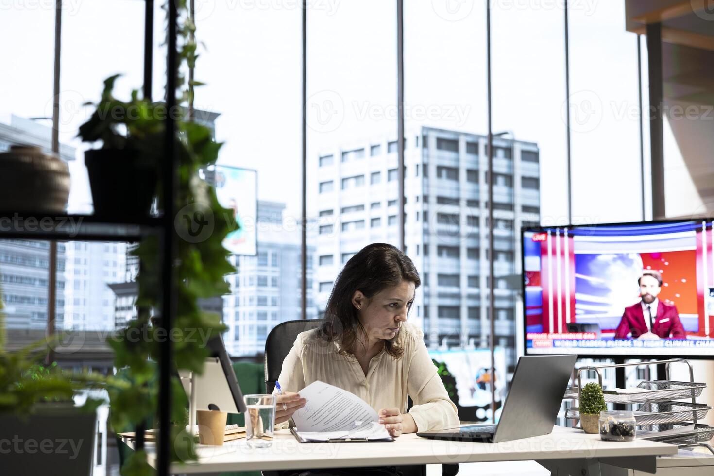 Female director signing legal management paperwork and contracts, giving her authorization for license agreements and leave requests from employees. CEO deals with documents in office. photo