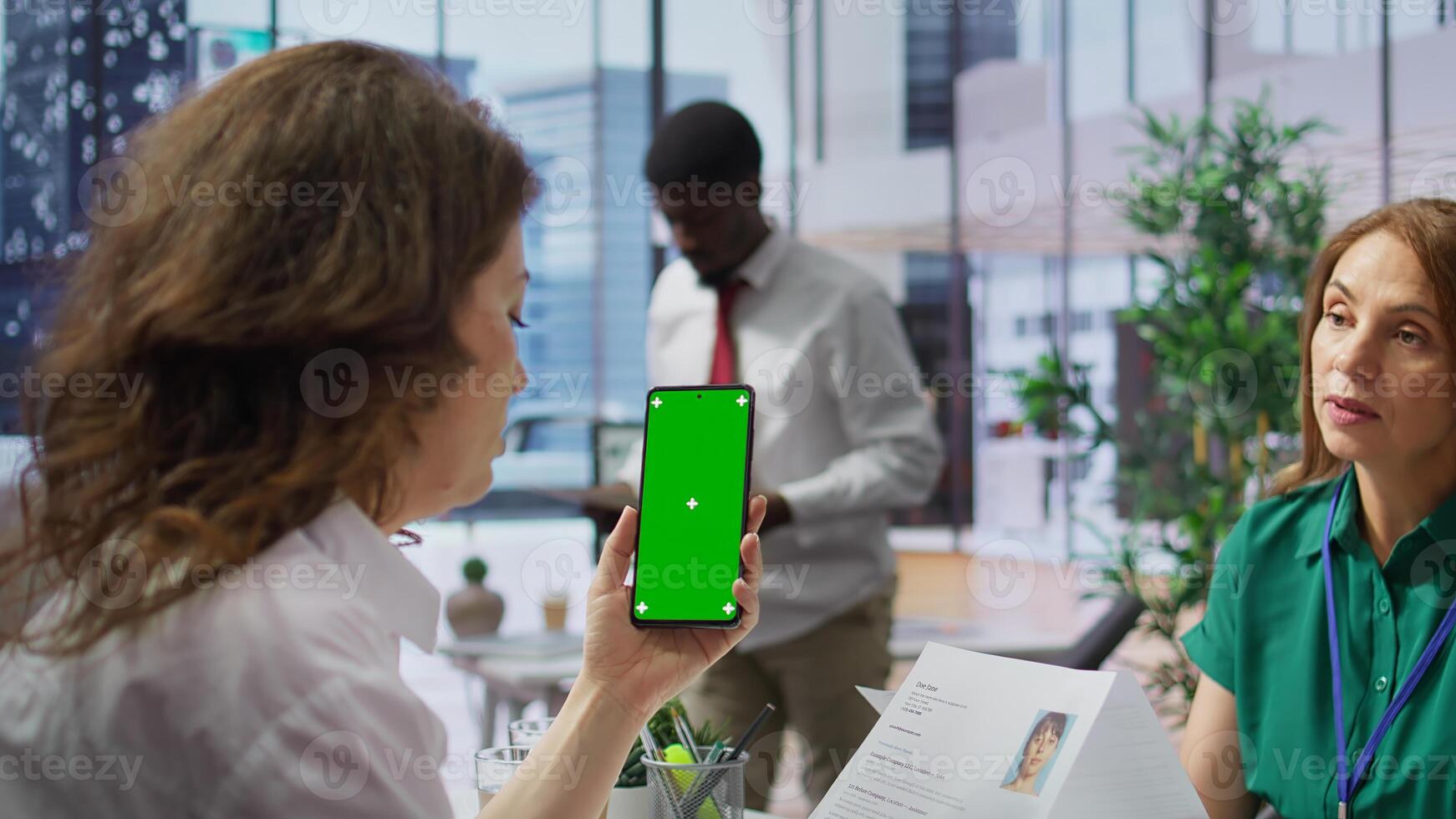 Recruiters team evaluating applicants resumes next to a green screen, looking at qualifications and work experience. HR experts selecting candidates to fill in a job vacancy at corporation. Camera B. photo
