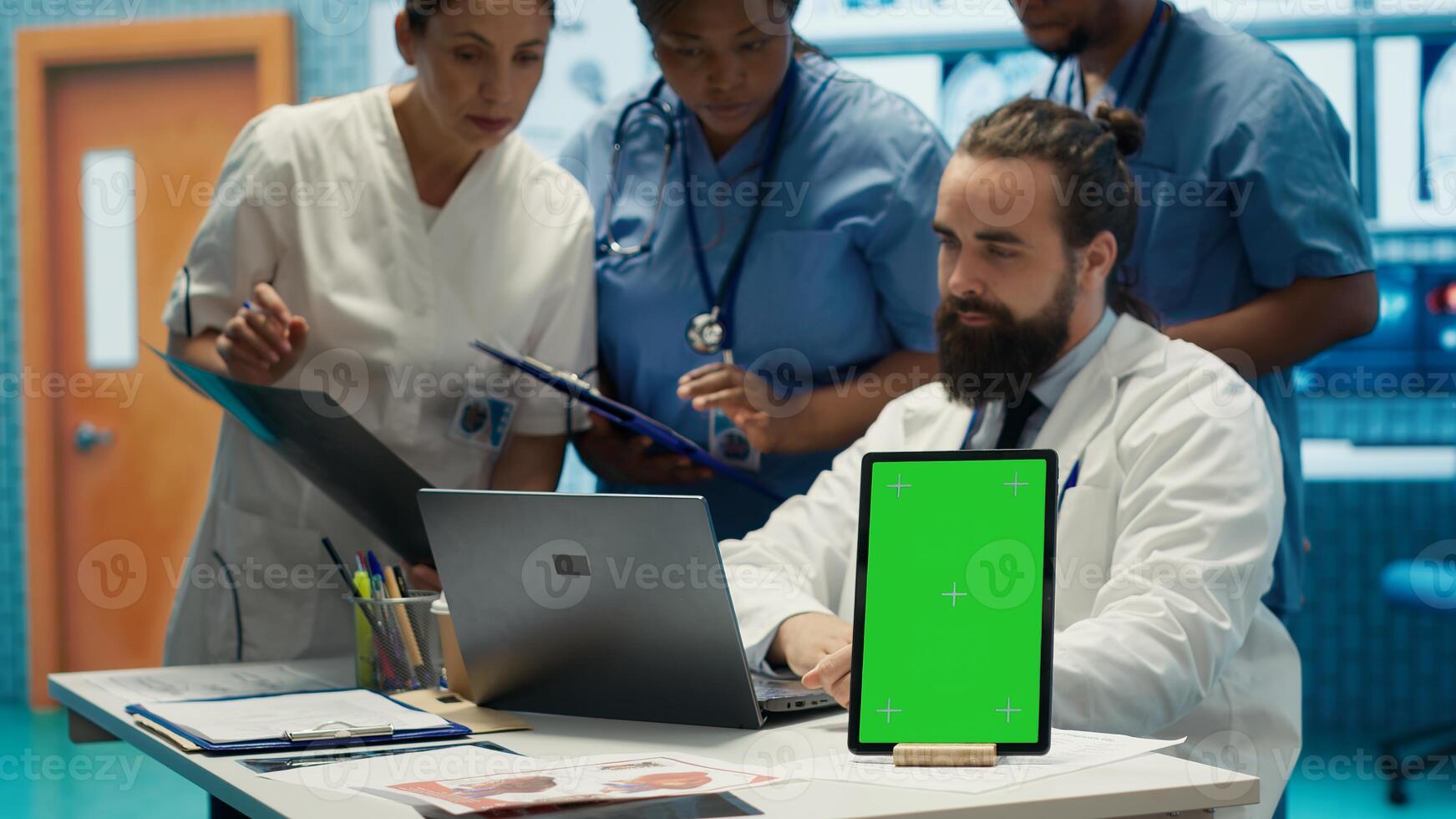 Group of doctors consulting hospital records next to chroma key display, using x ray test results to examine diagnosis. Diverse experts meeting at private clinic to provide treatment plan. Camera A. photo