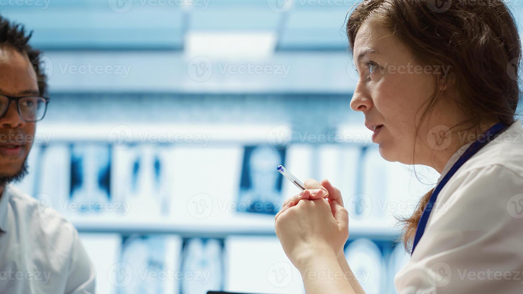General practitioner consults patient about diagnostic test results, utilizing medical technology for accurate analysis and care management in a clinical environment. Healthcare provider. Camera A. photo