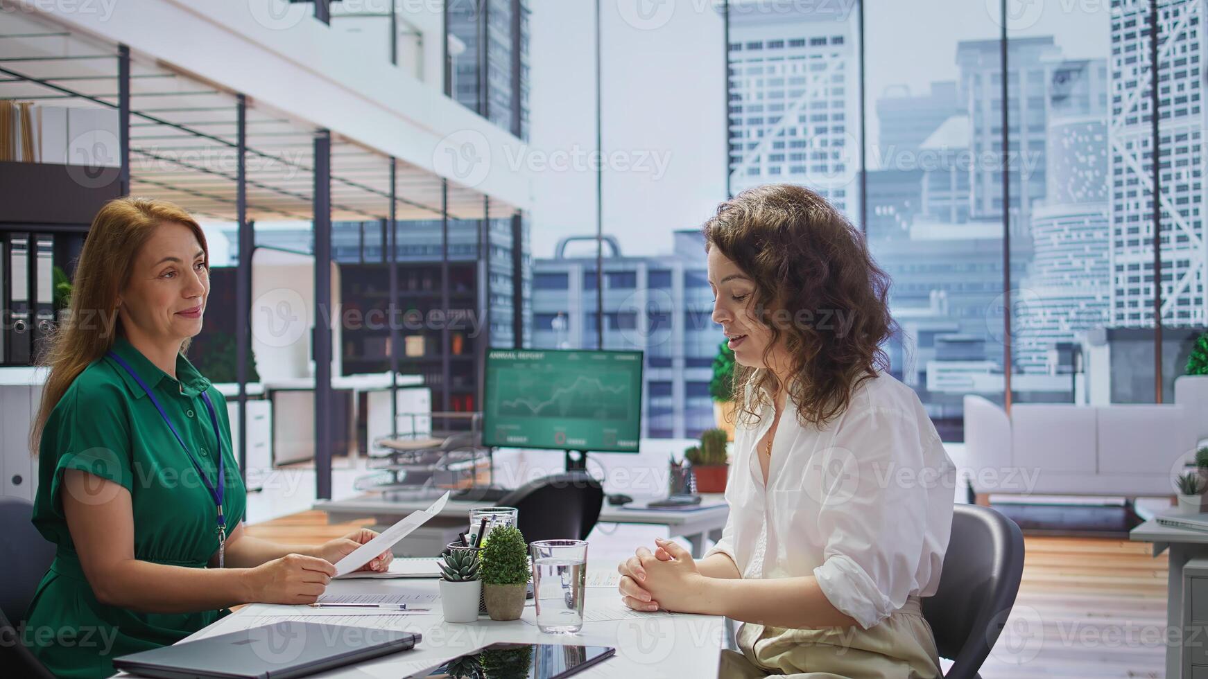 Interviewer reviewing the CV of a candidate during a job interview, assessing their skills, experiences and how they align with the company strategic goals. Employment and recruitment. Camera B. photo