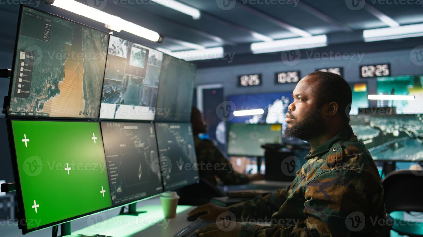 Air force officer performing tactical level surveillance in command room using mockup screen. Military specialist using radar on chroma key gear to look at assault zones, camera B photo