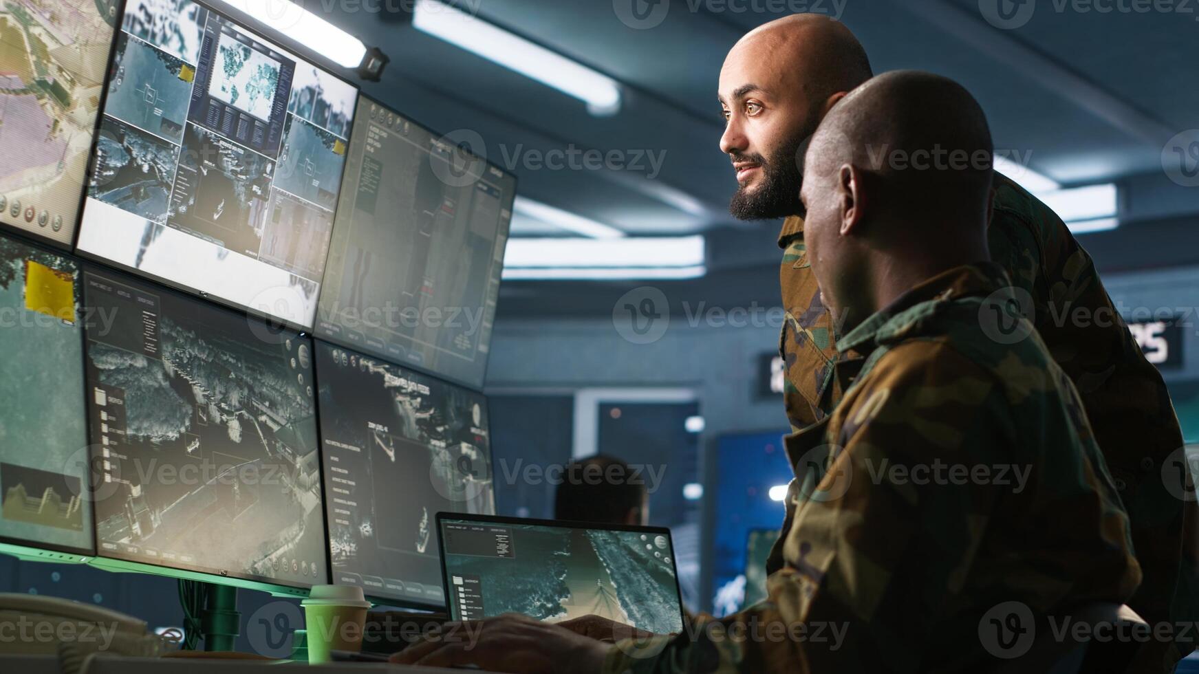 Army colleagues looking at screens in command center housing operational missile defense system designed to intercept ballistic rockets. Experts using tracking gear and radar systems, camera A photo
