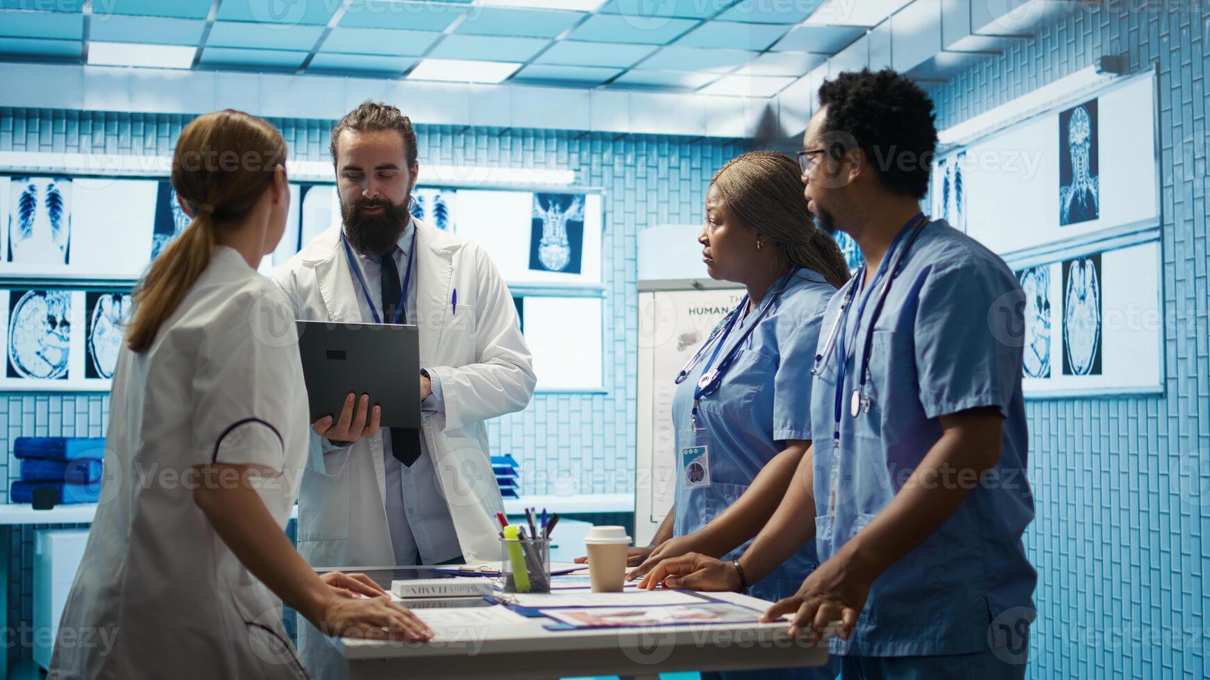 Neuroscience expert reviewing mri brain scan results with doctors, discussing the right treatment plan for disease prevention. Licensed neurologist and his staff examine tomography. Camera B. photo