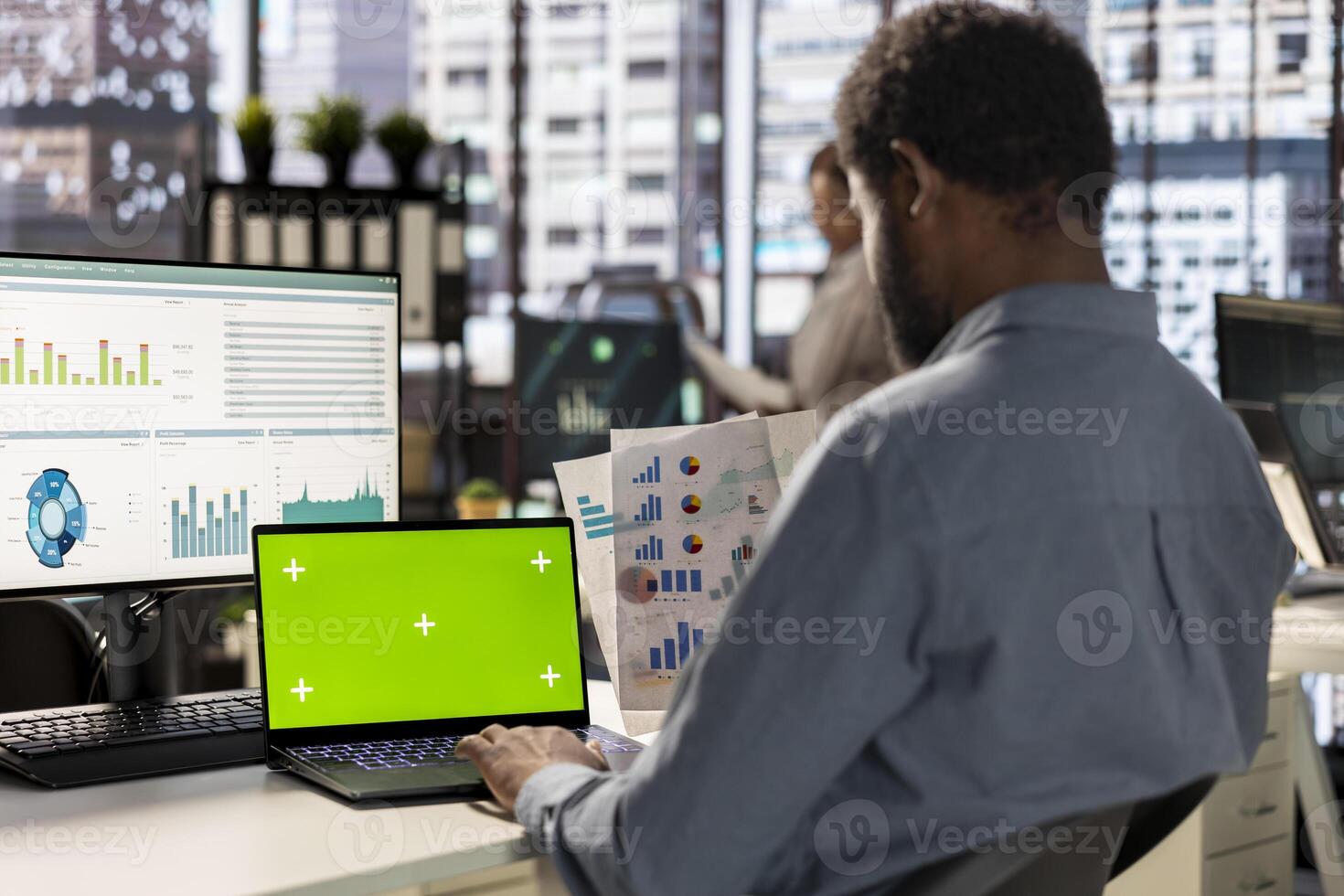 Corporate executive worker focused on strategic planning next to green screen on pc, accomplishing business objectives. Male manager engaged in budget analysis and performance metrics. photo