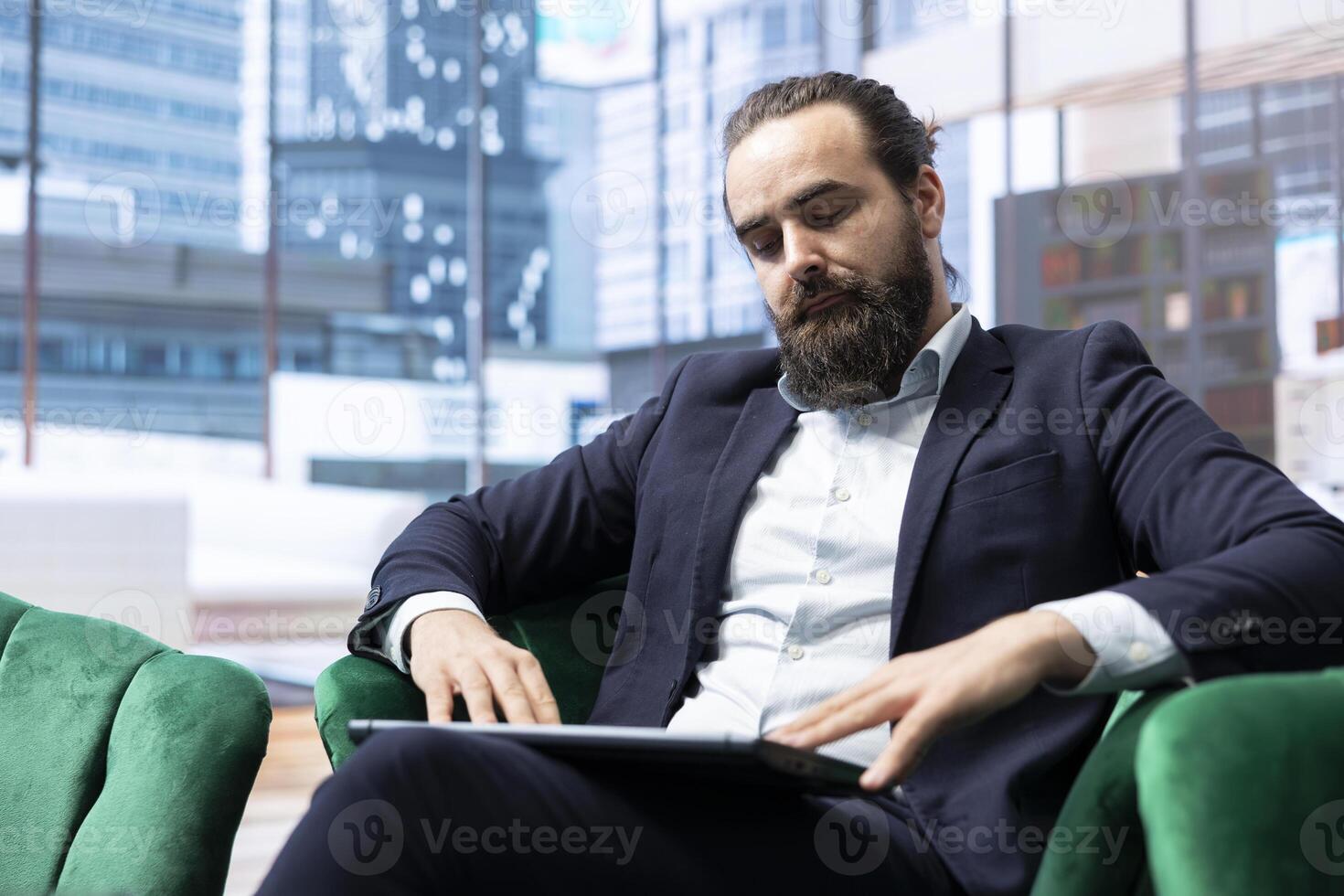Ambitious leader in a luxurious headquarters plans business expansion, balancing profit reports and evaluating market trends on his laptop. Making data driven decisions for enterprise success. photo