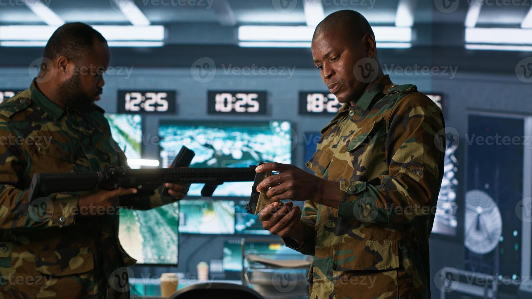 Team of army soldiers in command center packing weapons able to engage targets at extended range. Military units reloading gun cartridge, preparing for enemy assault mission, camera A photo
