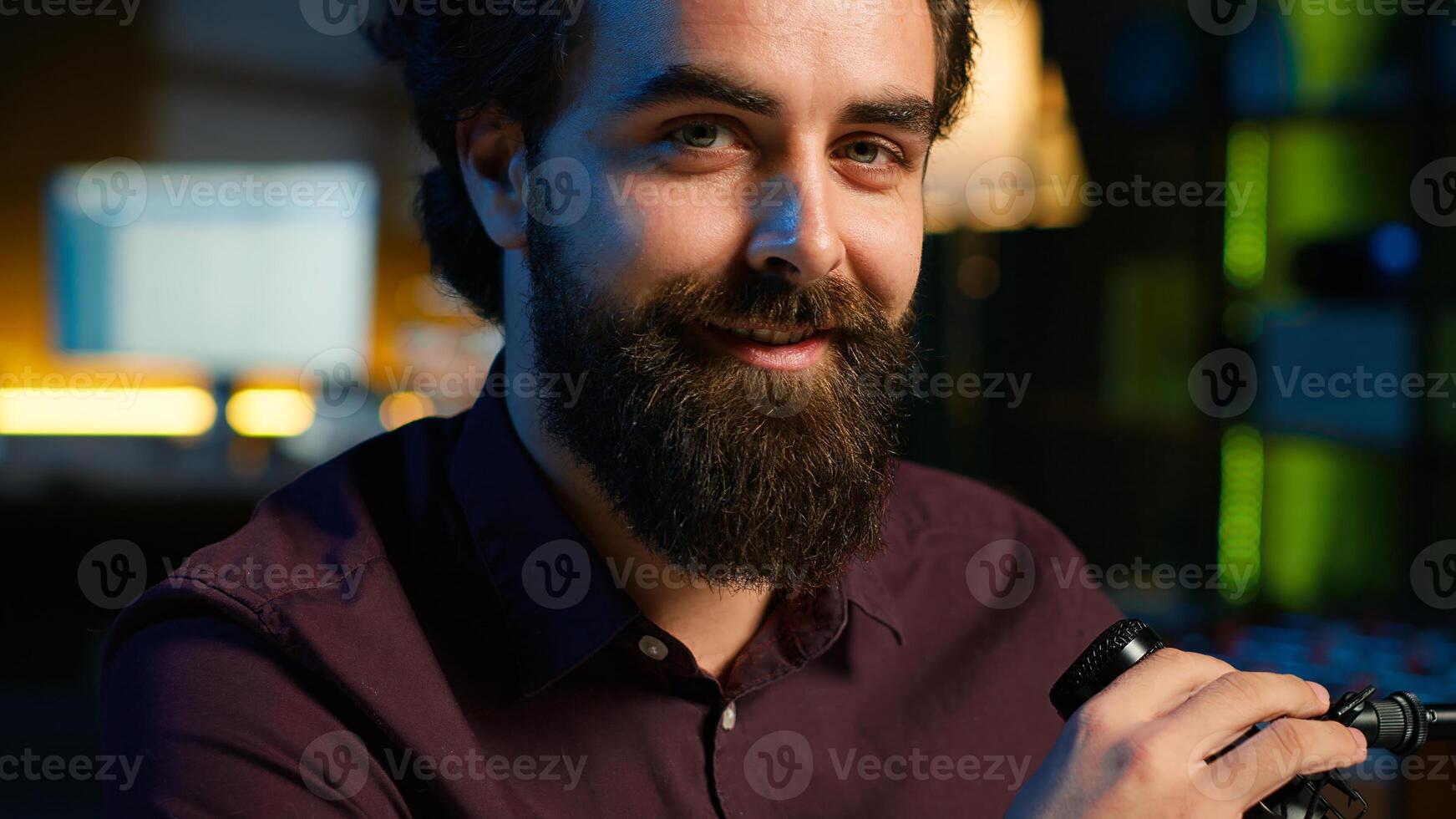 Portrait of smiling influencer in home studio doing live broadcast for online streaming platforms, talking with fans. Jolly media star telling viewers facts about himself, camera A close up photo