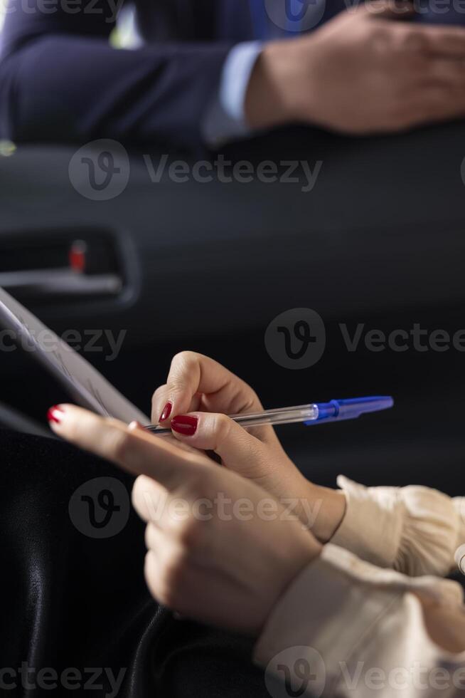 Customer signing sale contract after finishing test drive in car dealership. Close up of client writing signature after agreeing with showroom agent suggesting buying extra features photo
