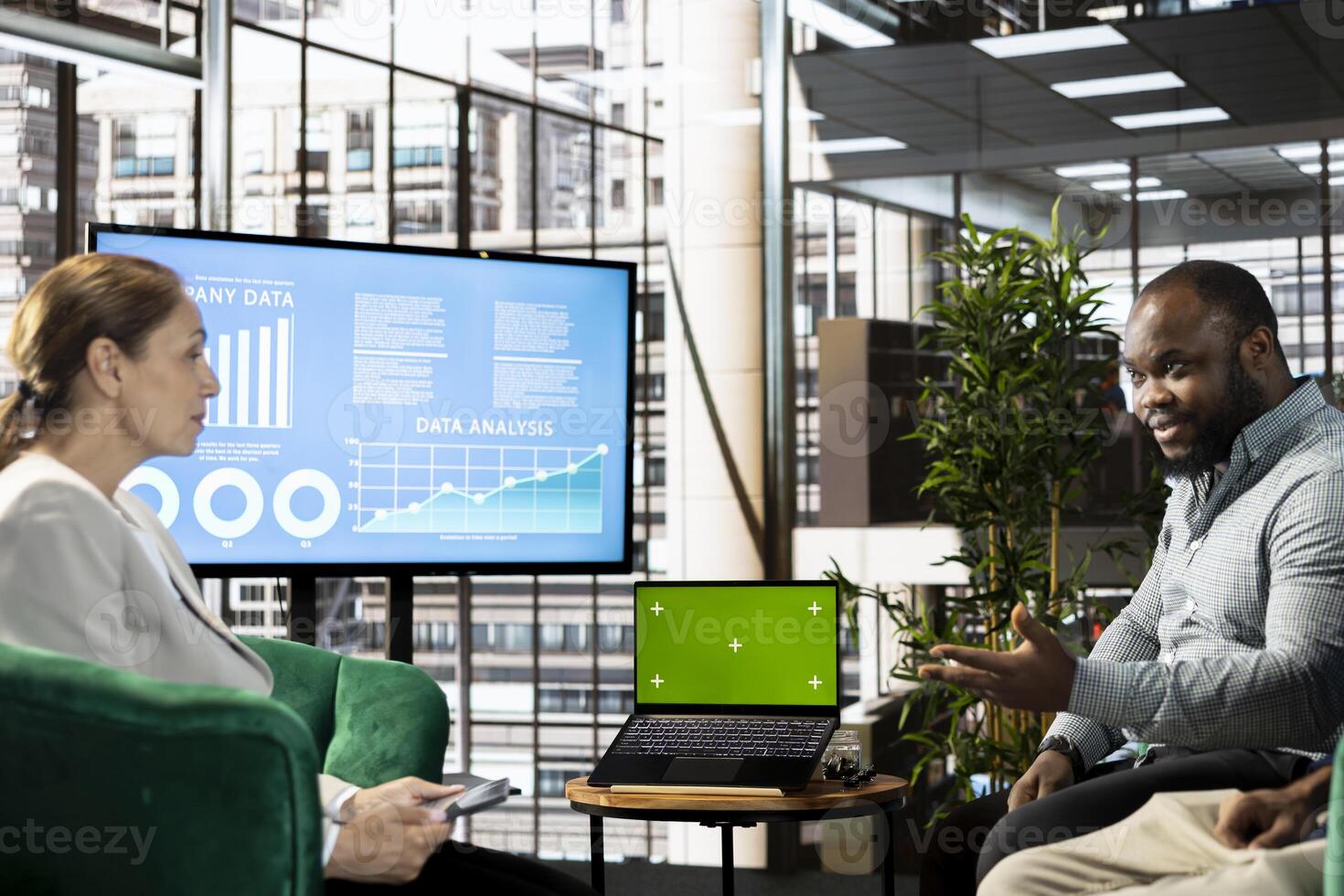 Woman looking at green screen laptop with manager, presenting him key research data needed for finding business insights and finishing project task. Employees analyzing data on chroma key notebook photo