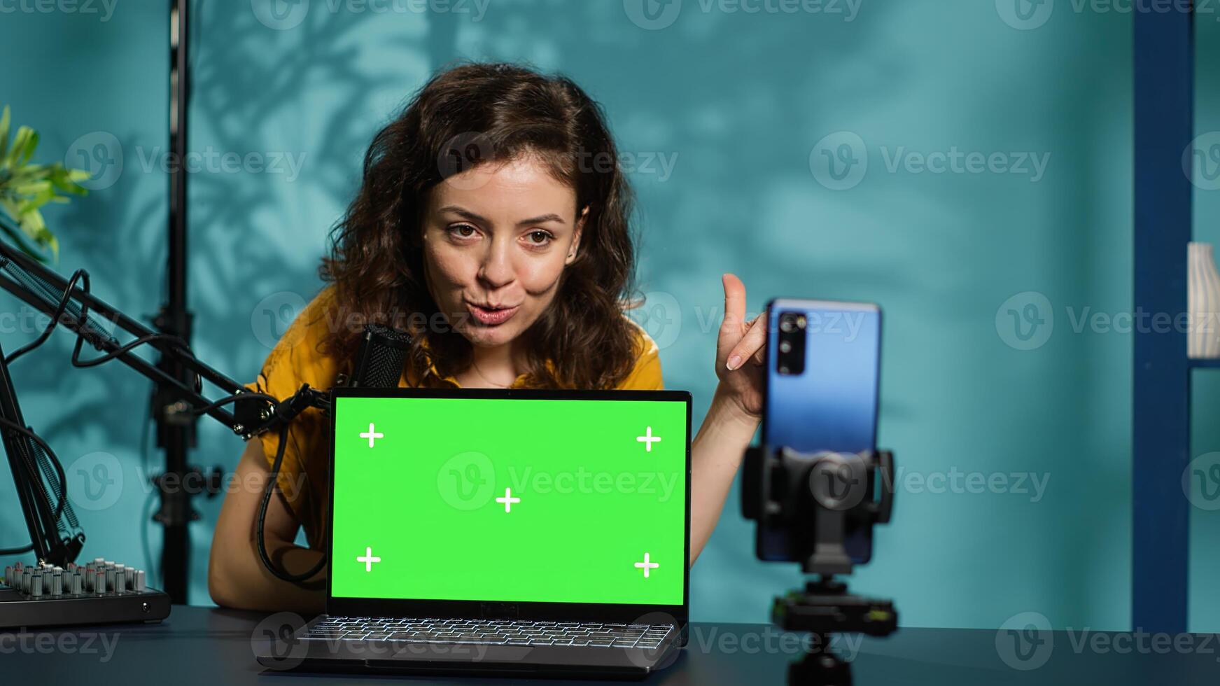 Internet show host being sponsored by partnering brand to do green screen laptop unboxing content. Tech specialist does influencer marketing, doing mockup notebook product placement, camera A photo