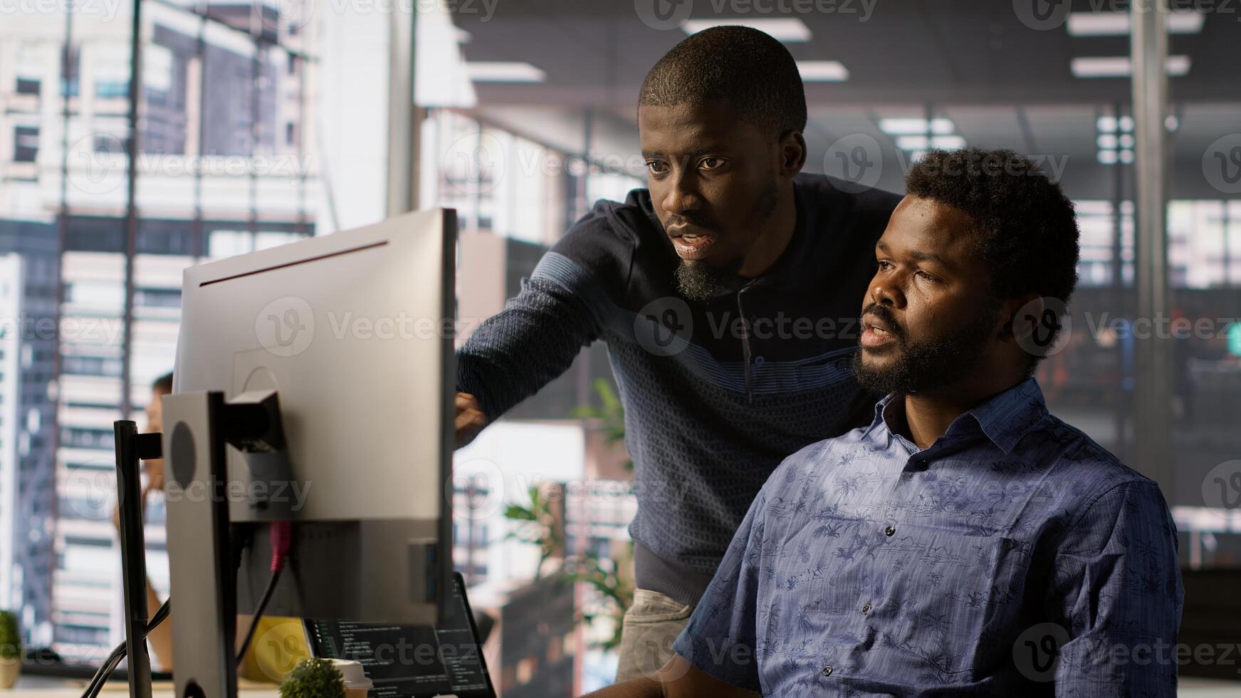 Admin assisted by coworker, working with machine learning artificial intelligence critical to autonomous systems. IT staff members working together to transform data into predictive models, camera A photo