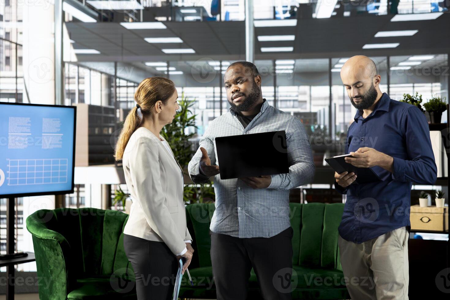 Colleagues doing briefing meeting to share new ideas for profit growth, looking at notebook. Teamworking employees in office talking with director, explaining startup evolution vision photo