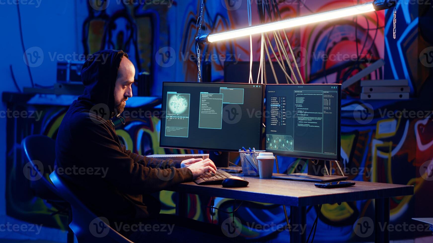 Skilled hacker deploying malware on unaware victims computers, stealing sensitive and private information, selling on darknet to highest bidder, looking at computer screen in hideout, camera B photo