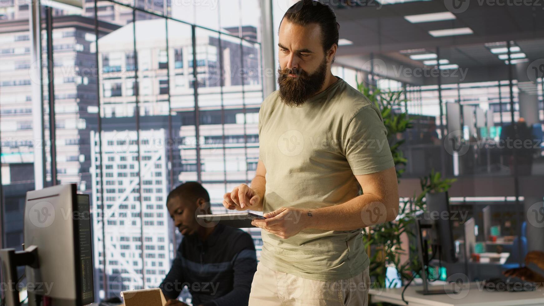 System administrator checking results on tablet after creating complex machine learning models that can process and analyze vast amounts of data. Admin standing in office, looking at device, camera A photo