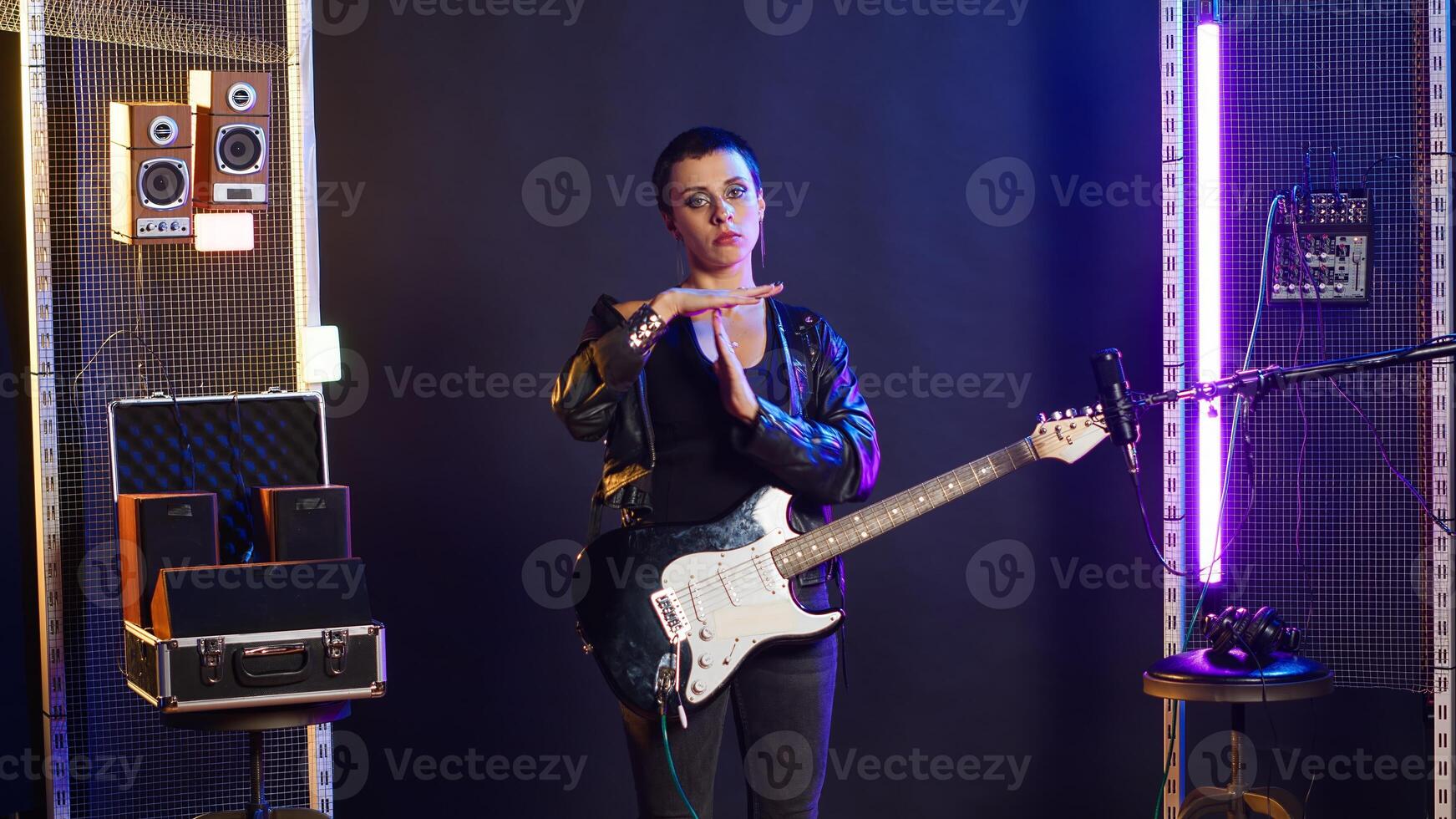 Grunge fierce cool artist doing the timeout symbol in the studio, asking for a break and performing live alternative music. Iconic edgy musician singing heavy metal music. Camera B. photo