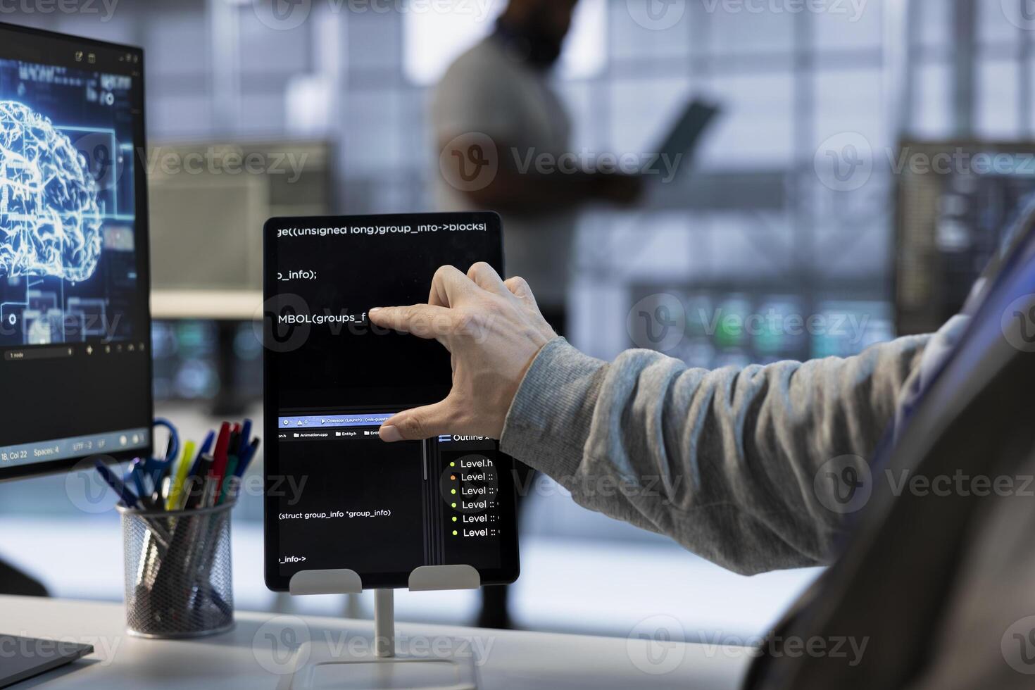 Technician optimizing data center workspace with tablet for maximum efficiency and uptime. Programmer in server hub maintaining optimal network performance, performing backups using device, close up photo