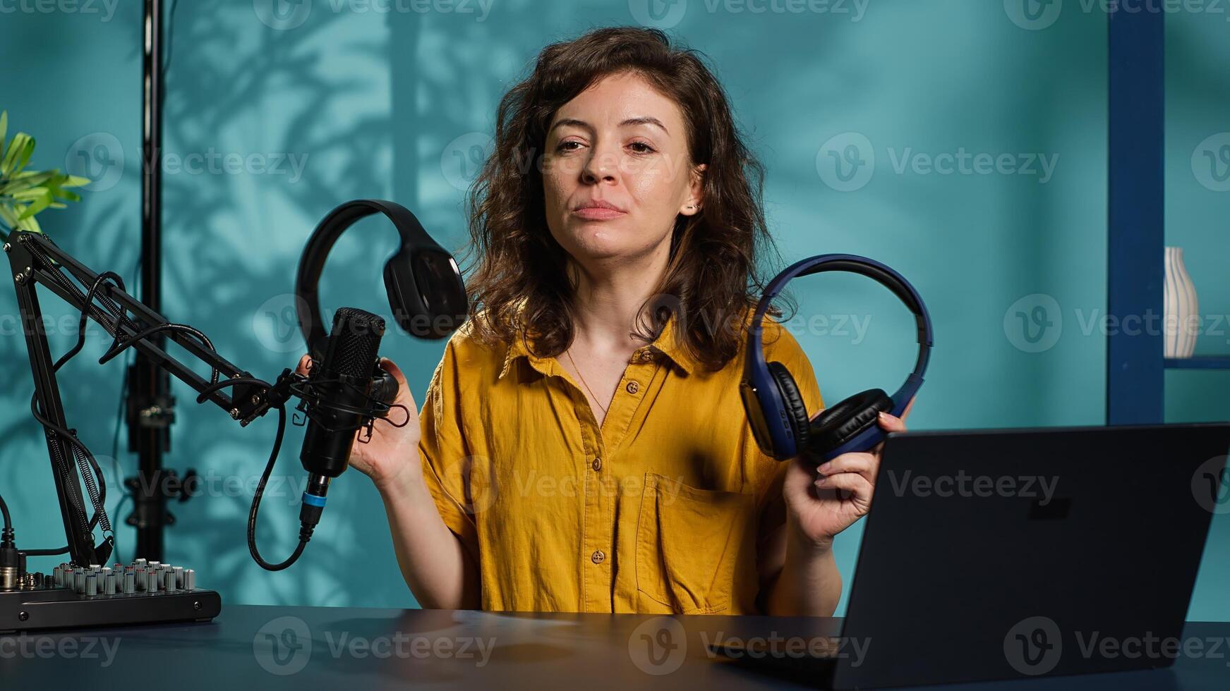 Audio technician presenting professional headphones in different price ranges to audience, comparing them to find winner. Expert recommending listening devices to fans, doing review, camera A photo