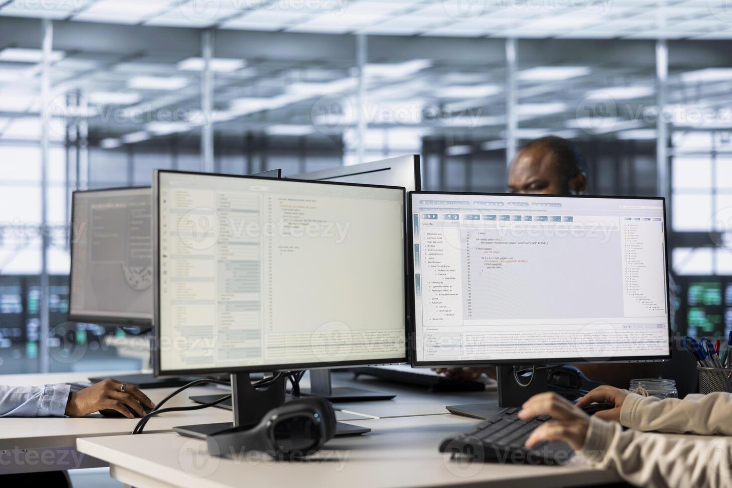 Lines of code running on computer screens in data center, used by employees to troubleshoot rackmounts in server rows. IT scripts ran by workers on PC monitors, upgrading hardware photo