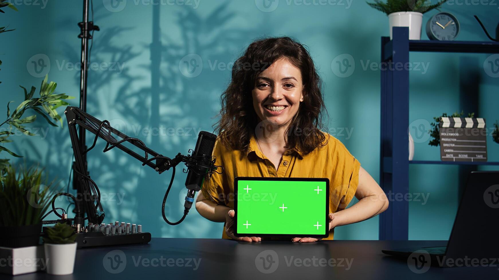 Cheerful media star being sponsored by partnering brand to do mockup tablet unboxing content. Upbeat tech expert does influencer marketing, presenting green screen device, camera B photo
