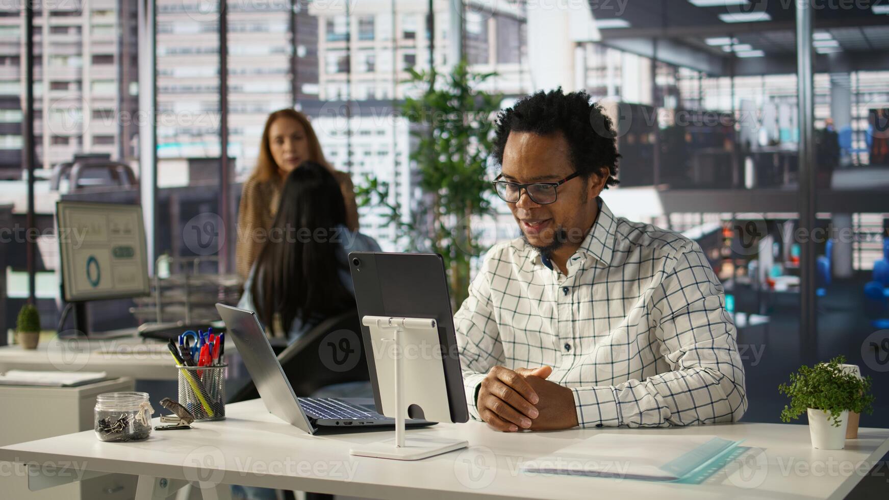 Professional businessman joins a digital meeting to discuss enterprise solutions and project goals. Attending a telecommuting session with shareholders for organizational development. Camera B. photo