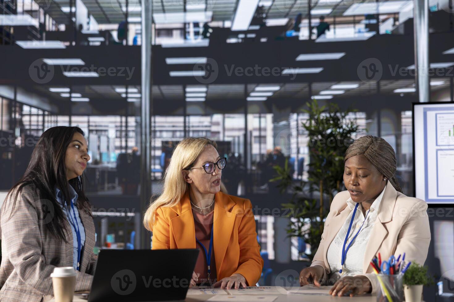 Multiethnic women executives uniting forces in a collaborative meeting, focused on data management and business development. Experts with leadership skills fighting for empowerment. photo
